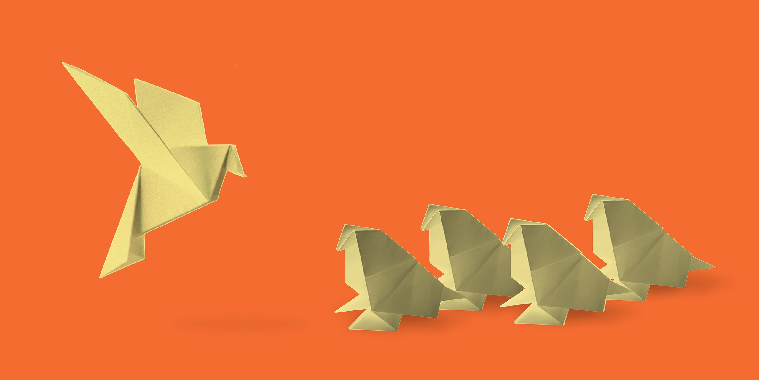 origami bird taking flight over sitting origami birds
